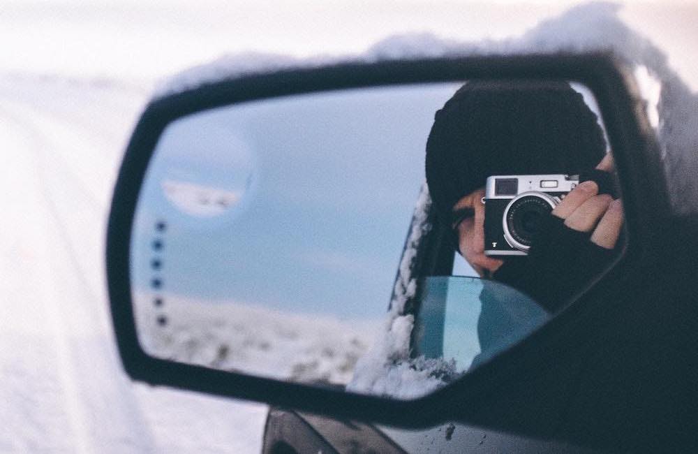 Observation of a photographer in the side mirror of a car
